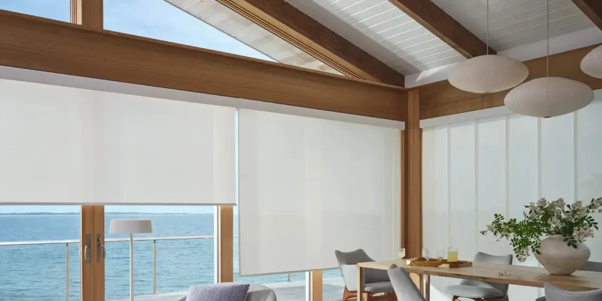Hunter Douglas Designer Solar Shades as sunroom window treatments in a space overlooking water