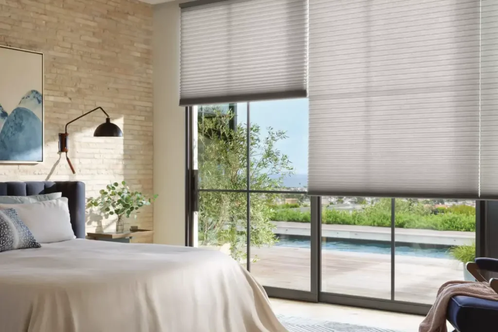 Hunter Douglas Duette® Cellular Shades on expansive windows, overlooking a scenic view, in a chic bedroom