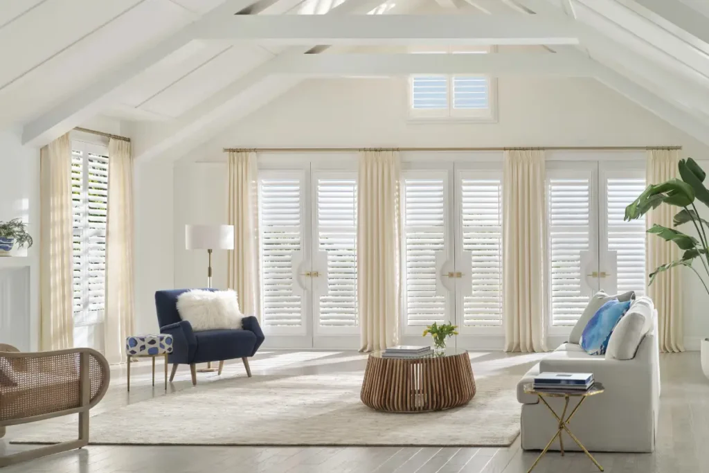 Hunter Douglas vinyl shutters on windows and three French doors in a bright and airy space