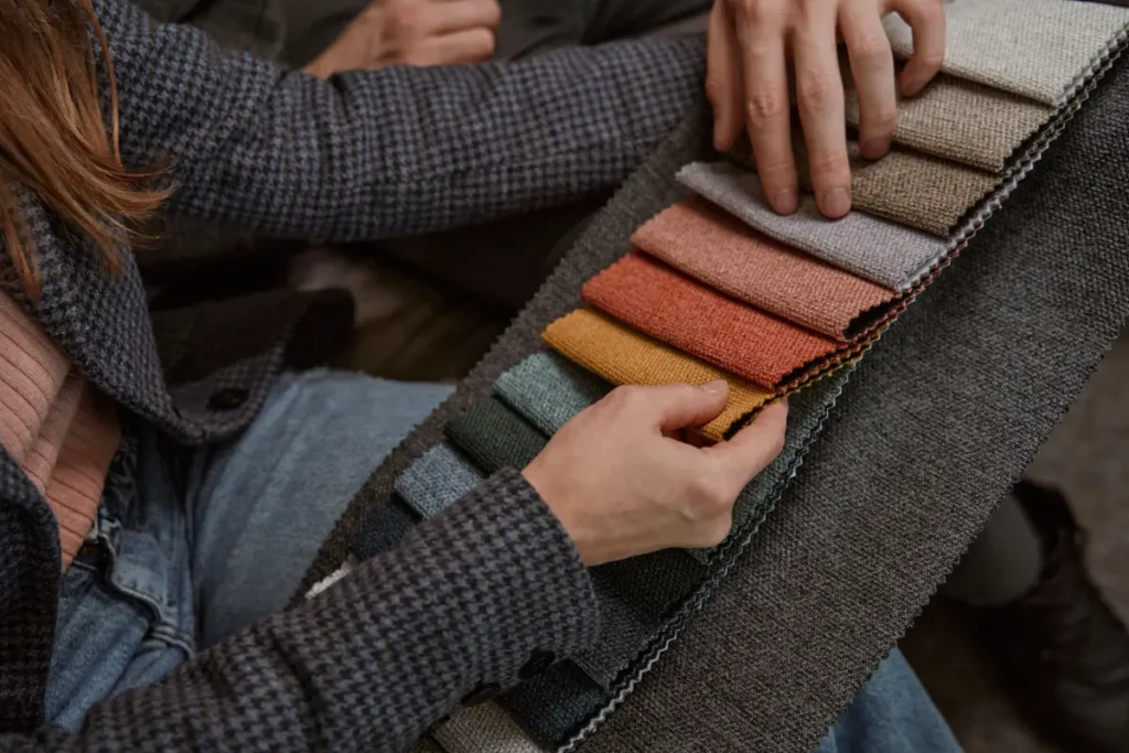 A window fashion specialist and Charleston homeowners comparing custom shade fabric samples in the Mount Pleasant showroom