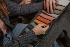 A window fashion specialist and Charleston homeowners comparing custom shade fabric samples in the Mount Pleasant showroom